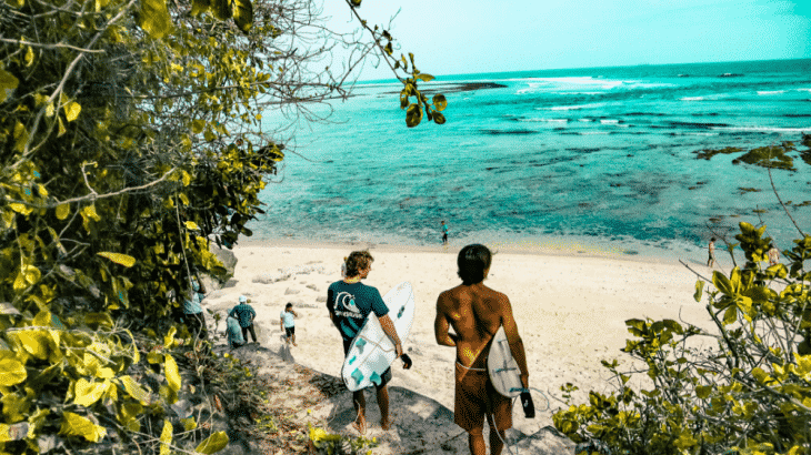 guys-holding-surf-boards-walking-to-turquoise-water