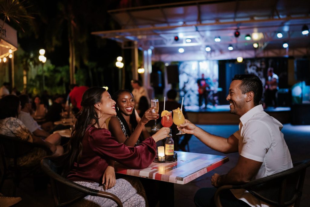 Friends gather at a bar with cocktails in Aruba.
