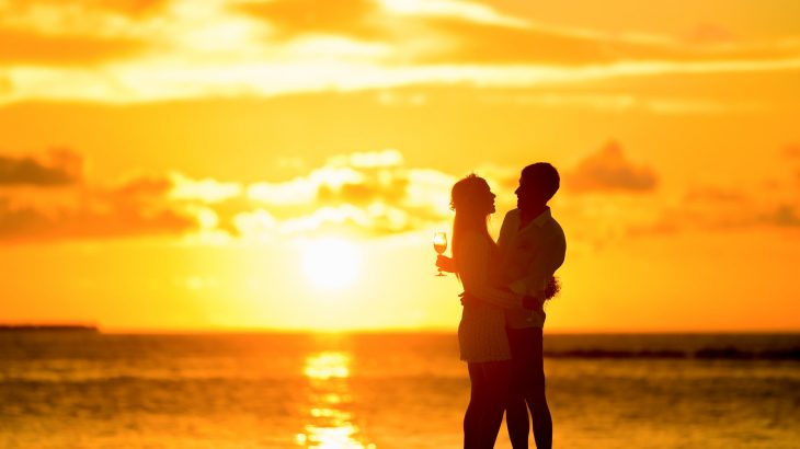 couple-holding-each-other-and-drinks-sunset