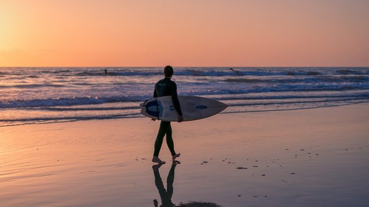 surfer-walking-with-board-sunset