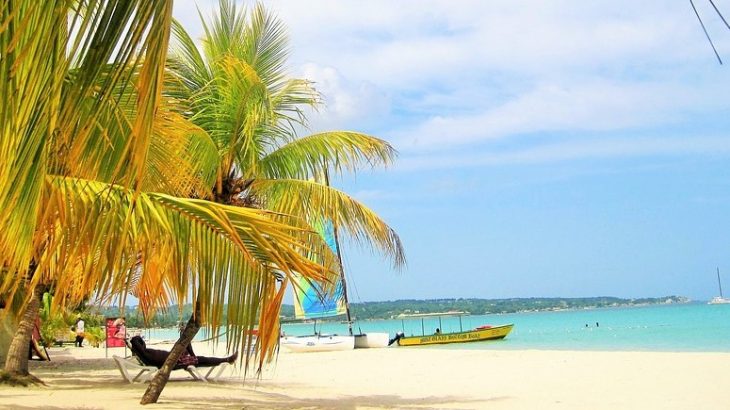 small-boat-teal-water-palm-trees