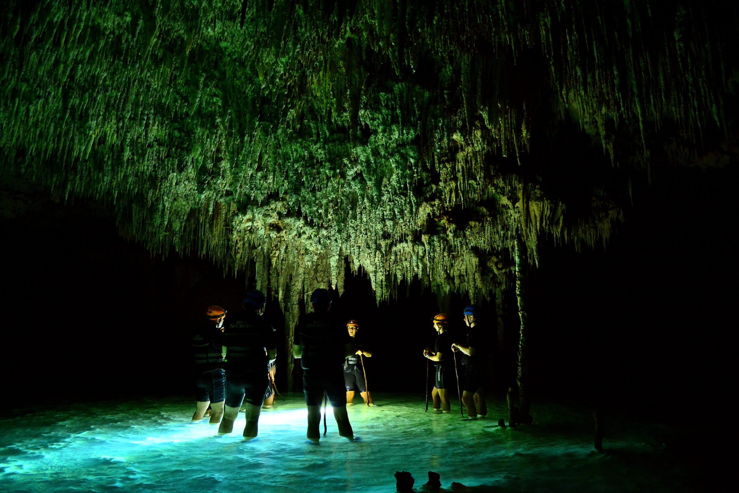 People in cenote cave with underground water system at Rio secreto, Mexico.