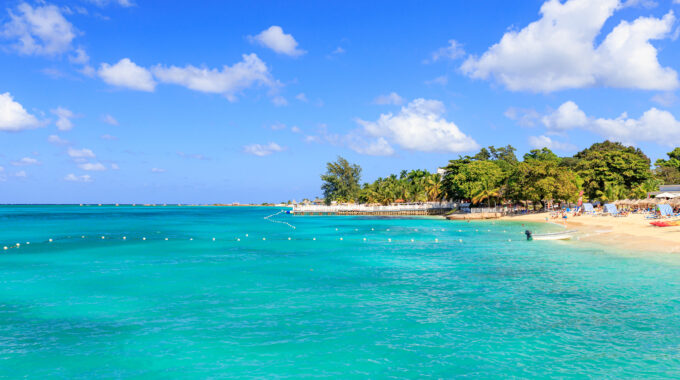 Beach with turquoise water at Doctor`s cave in Montego Bay Jamaica.