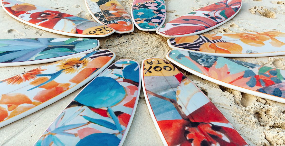 colorful surfboards in a circle laying flat on the beach