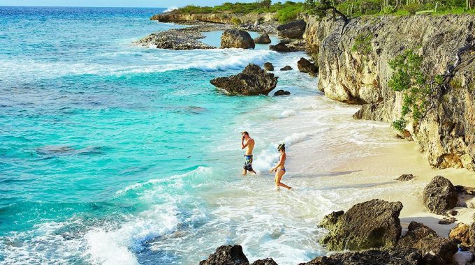 beach-snorkelers-turquoise-ocean-cliffs