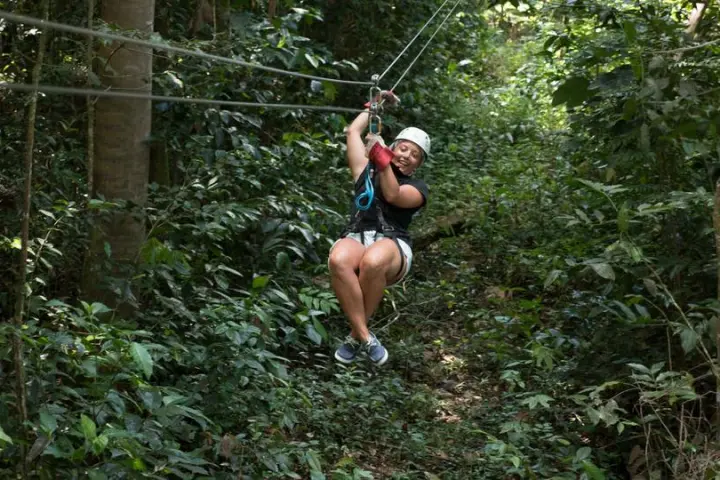 Girl rides a zip line at Treetop Canopy Adventure in St. Lucia.