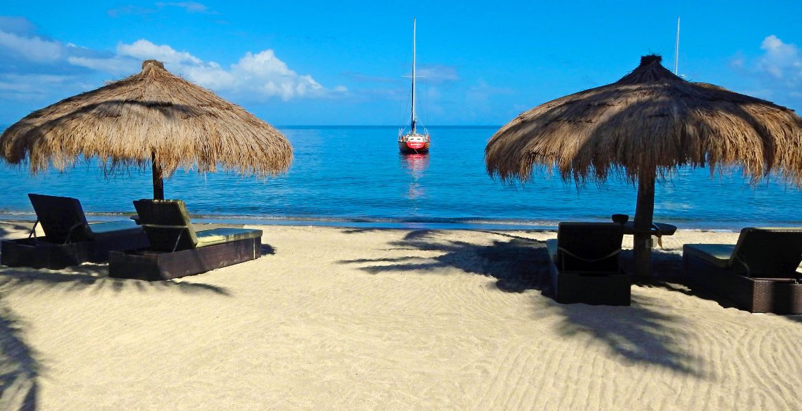 white-sand-beach-huts-blue-water-red-buoy