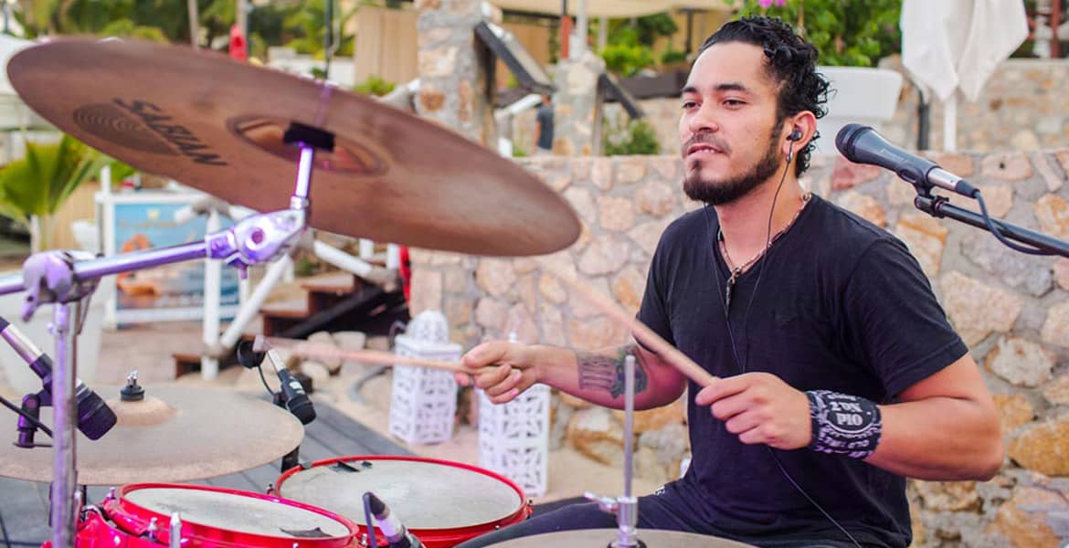 man-playing-red-rimmed-drums