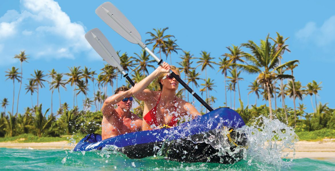 couple-kayaking-clear-water-green-palm-trees