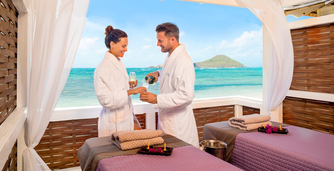 couple-at-open-spa-room-overlooking-blue-sea-green-island