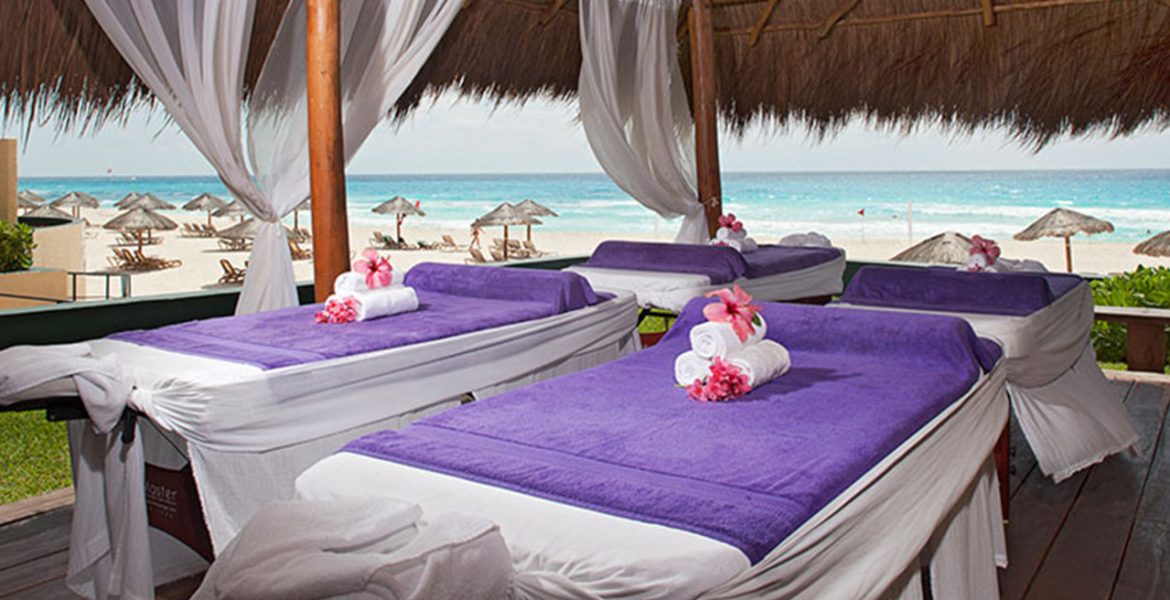 massage-tables-with-purple-blankets-on-beach