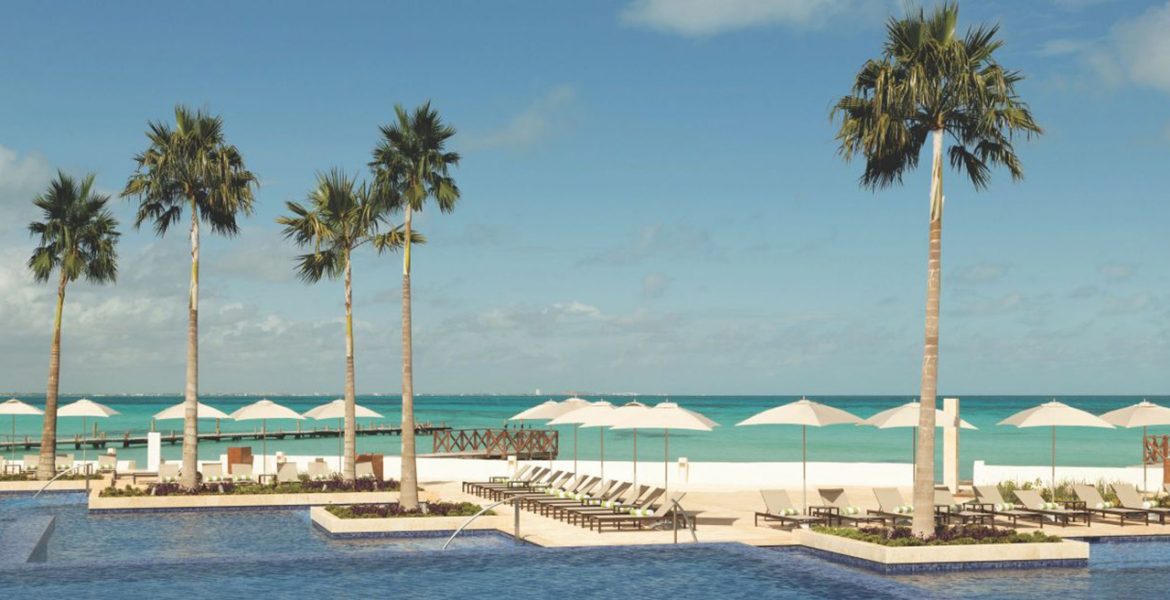 oceanfront-pool-palm-trees-white-umbrellas-ocean-background