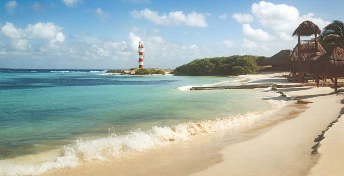 golden-sand-beach-turquoise-ocean-red-lighthouse-in-distance