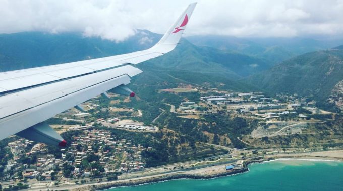 view-out-airplane-window-wing-island-mountains-turquoise-water