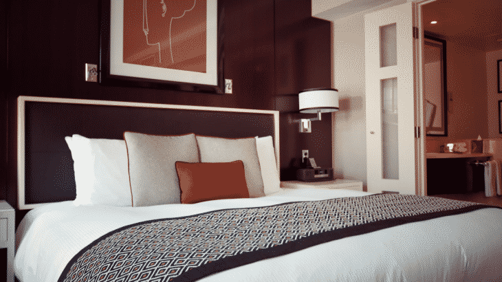 hotel-room-bed-with-orange-african-painting-above