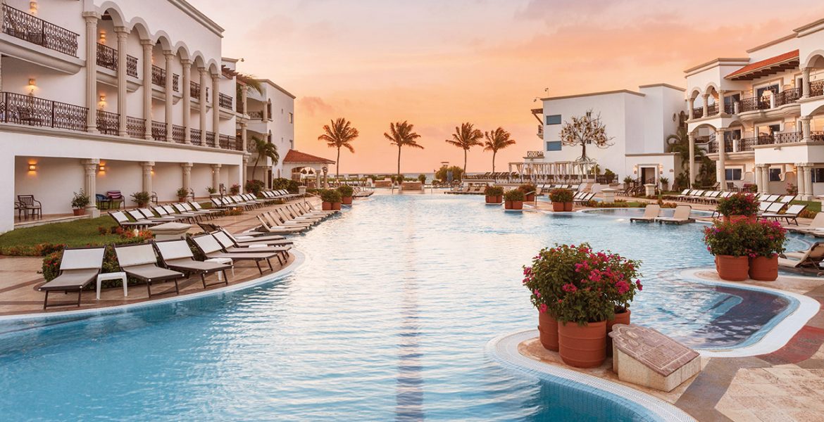 resort-blue-pool-sunset-palm-trees