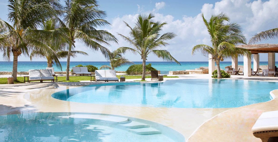 resort-pool-facing-ocean-palm-trees