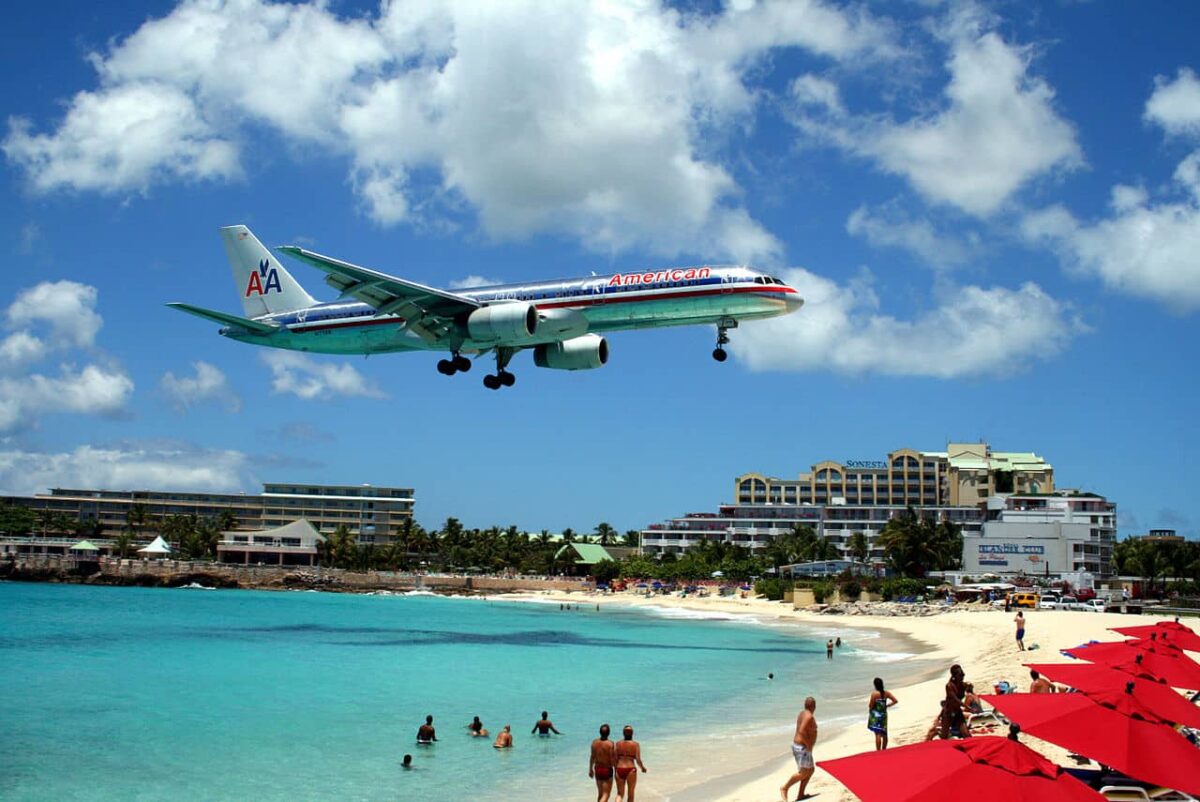 plane-flying-low-over-beach-people-watching