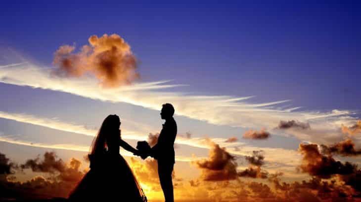 silhouette-bride-groom-in-front-sunset-clouds