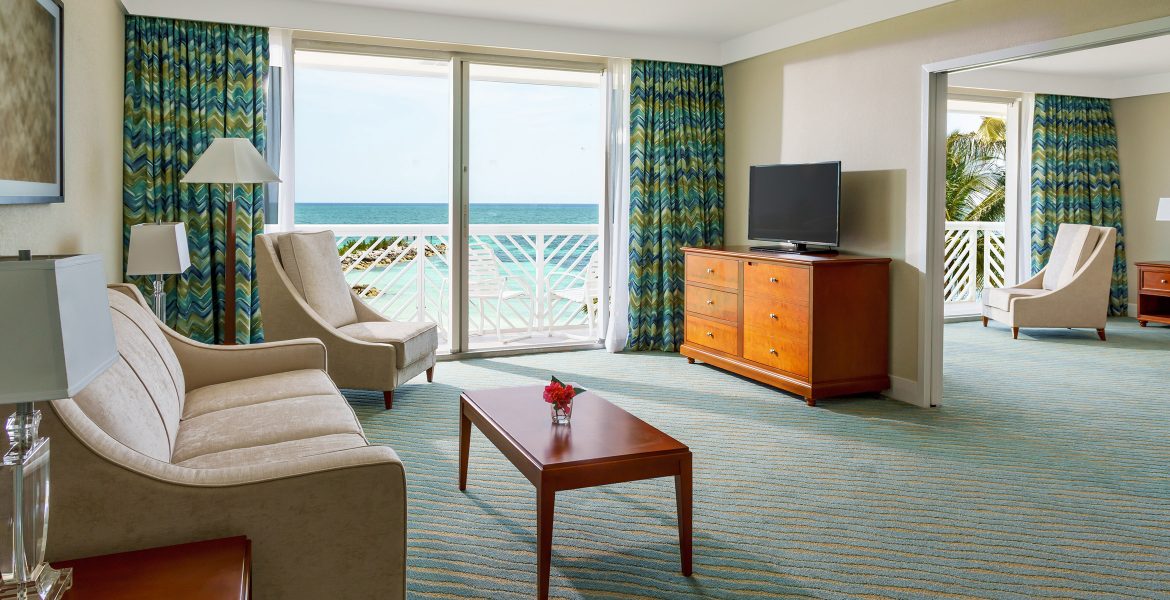 hotel-room-sliding-glass-doors-open-to-balcony-beach-view