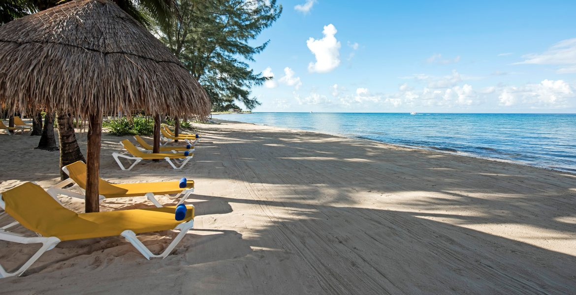 white-sand-beach-blue-ocean-yellow-loungers