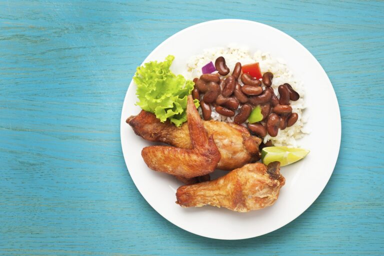 chicken-rice=beans-lettuce-white-plate-blue-background