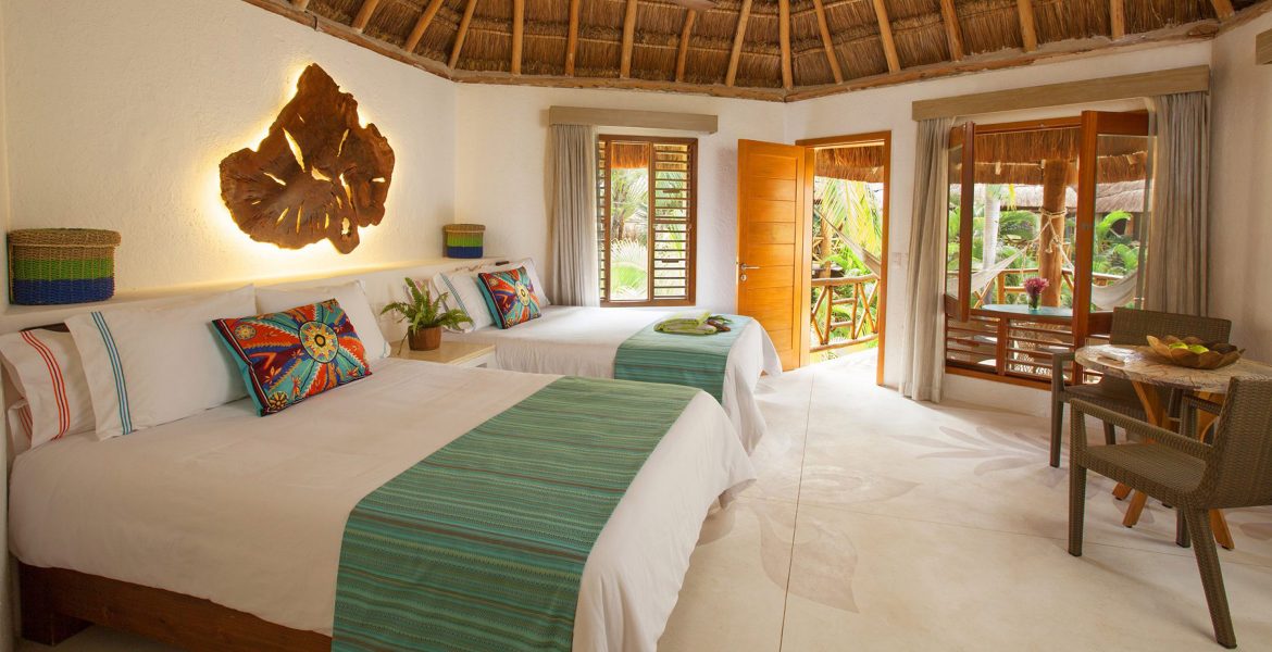 beach-hotel-room-white-beds-green-accents-thatched-roof