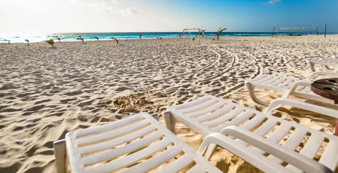close-up-white-loungers-sand-facing-ocean