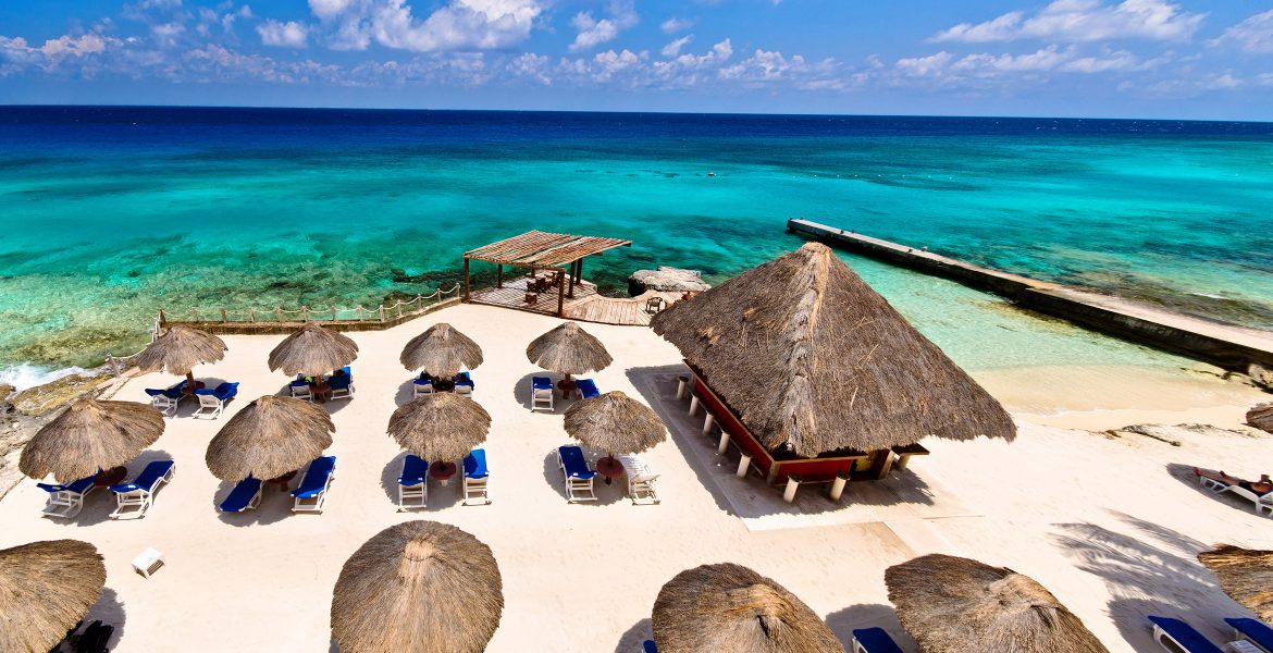 aerial-view-white-sand-beach-tiki-huts-turquoise-ocean