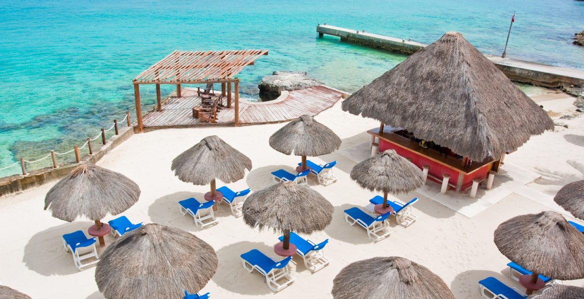 aerial-view-white-sand-beach-tiki-huts-turquoise-ocean