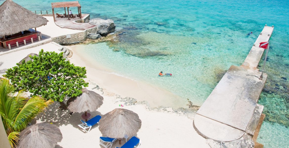 aerial-view-white-sand-beach-tiki-huts-turquoise-ocean