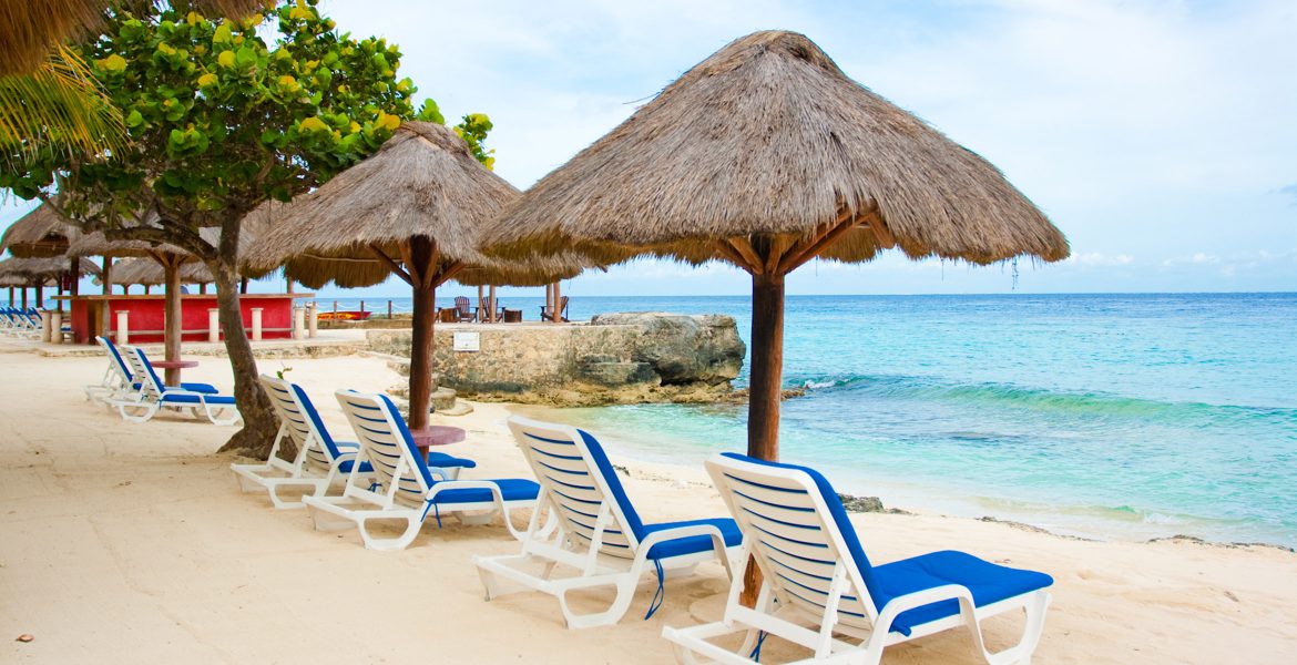 white-sand-beach-blue-loungers-tiki-umbrella-turquoise-ocean