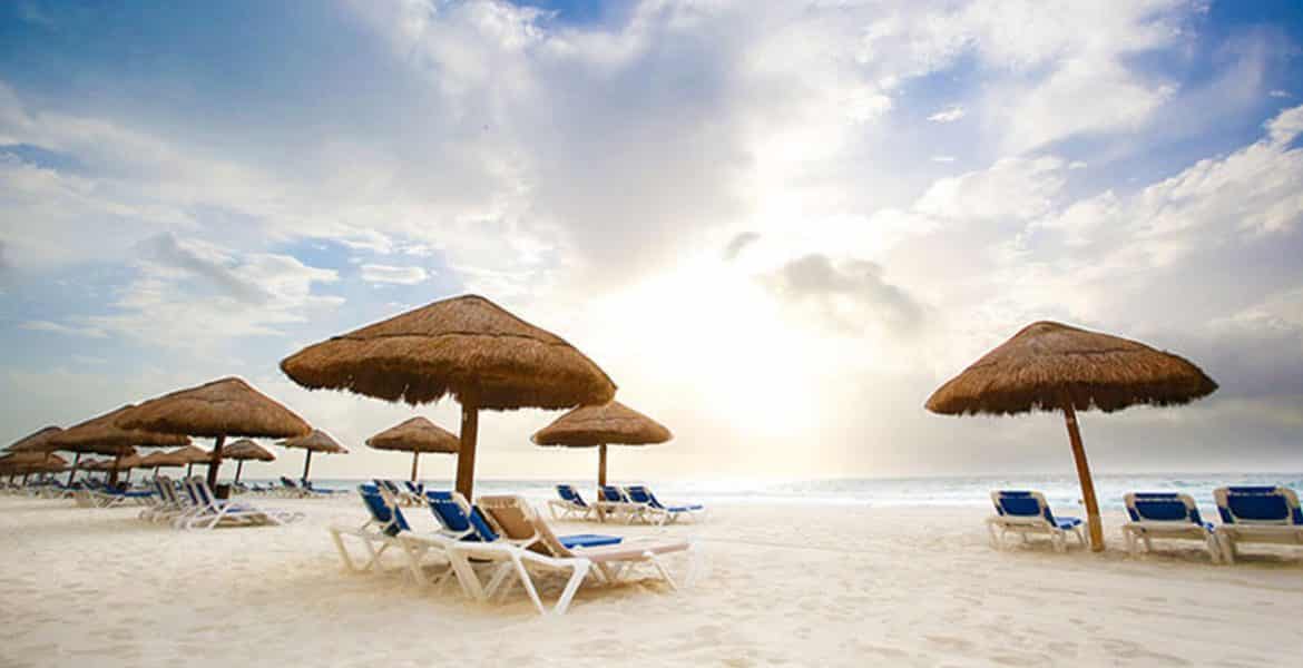 white-sand-beach-lounge-chairs-tiki-umbrellas