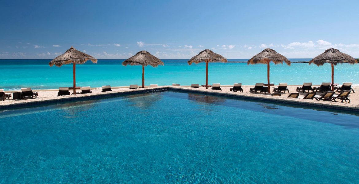 resort-pool-facing-ocean-tiki-umbrellas