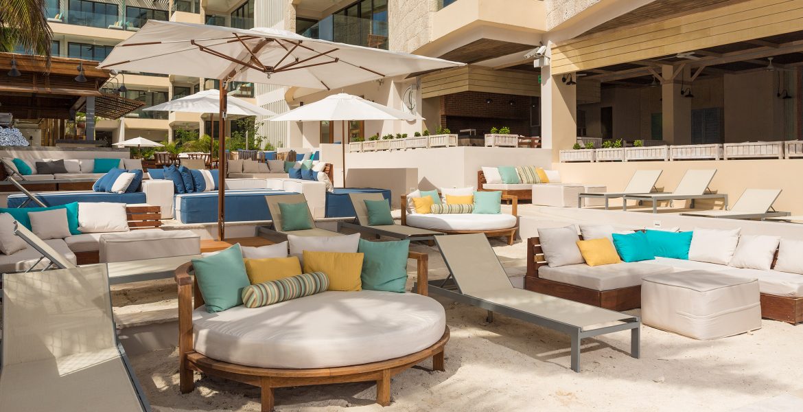 patio-seating-by-hotel-pool-couches-white-umbrella