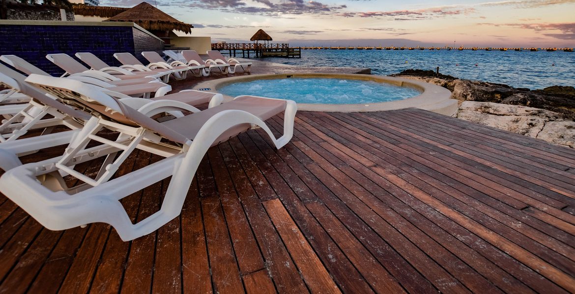 wooden-deck-white-deck-chair-blue-round-oceanfront-pool