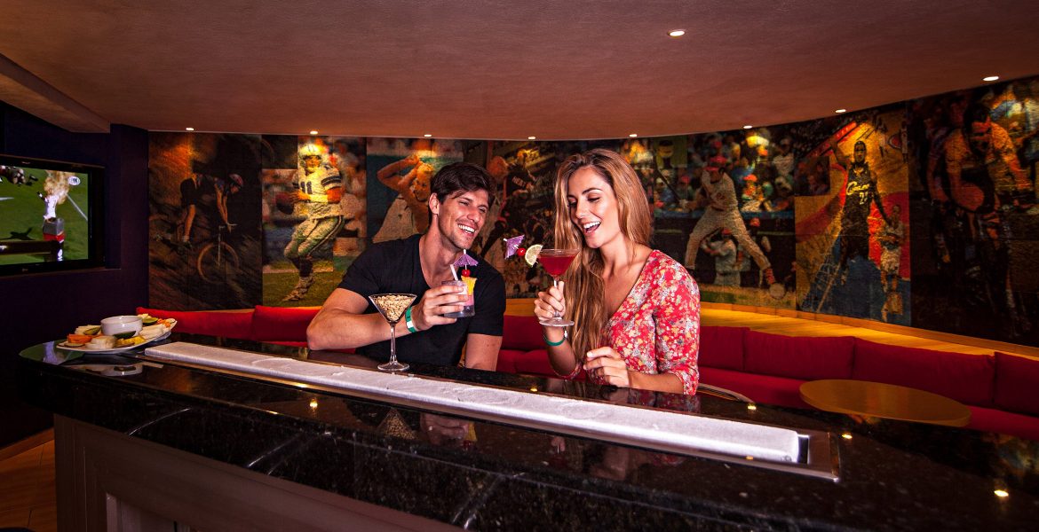 man-woman-looking-at-cocktails-sitting-at-bar