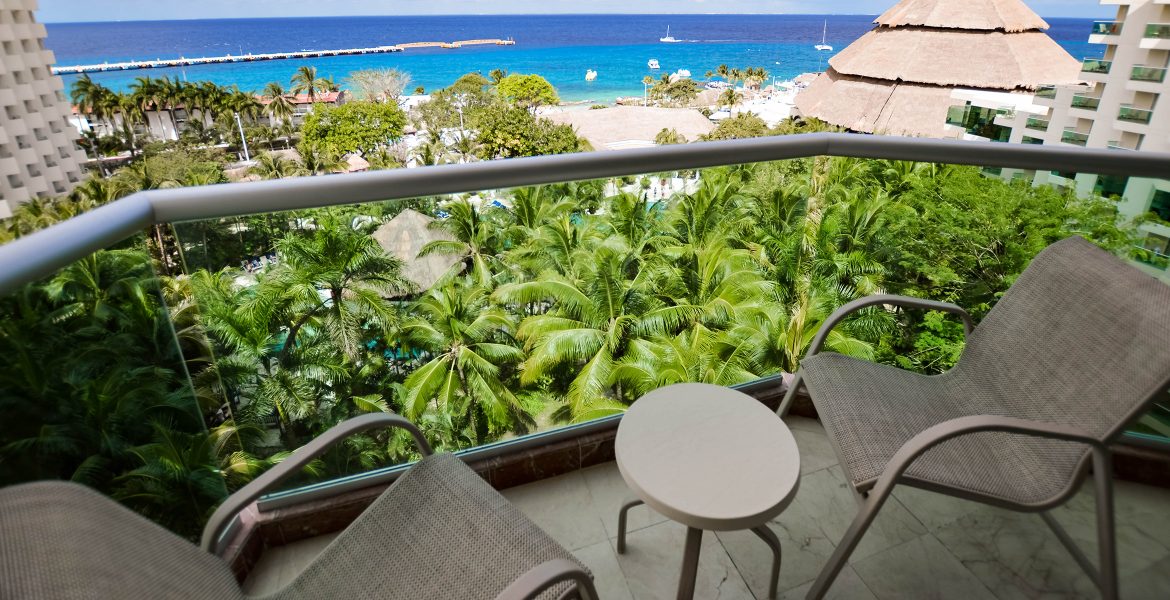 green-palm-tree-and-turquoise-ocean-view-from-hotel-room-balcony