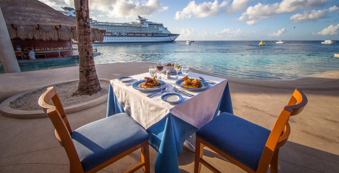 ocean-front-dining-blue-decor-food-on-table-cruise-ship-in-distance