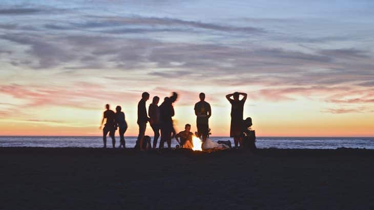 silhouettes-people-around-fire-on-beach-sunset