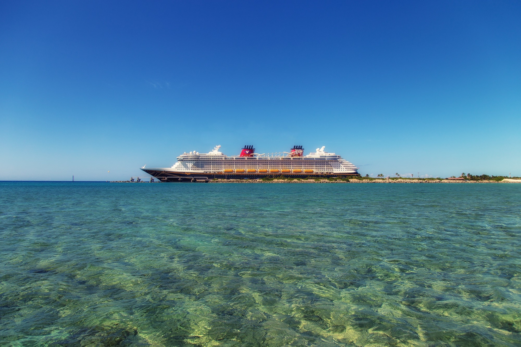 A cruise ship in shallow, crystalline blue waters 