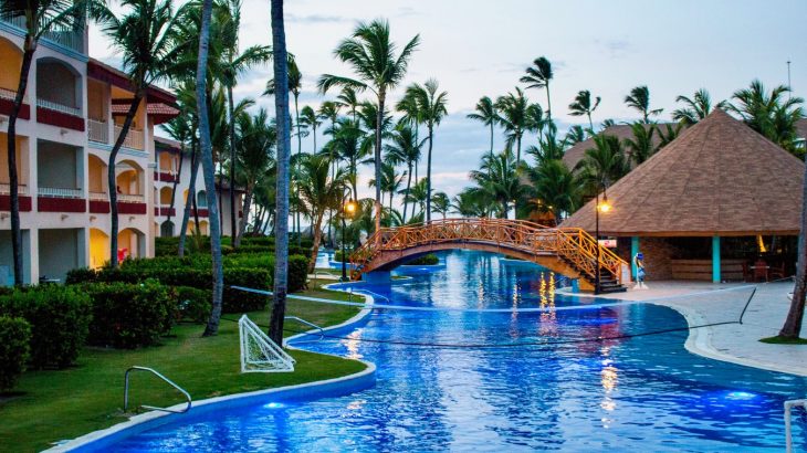 resort-river-pool-wooden-bridge-palm-trees-sunset