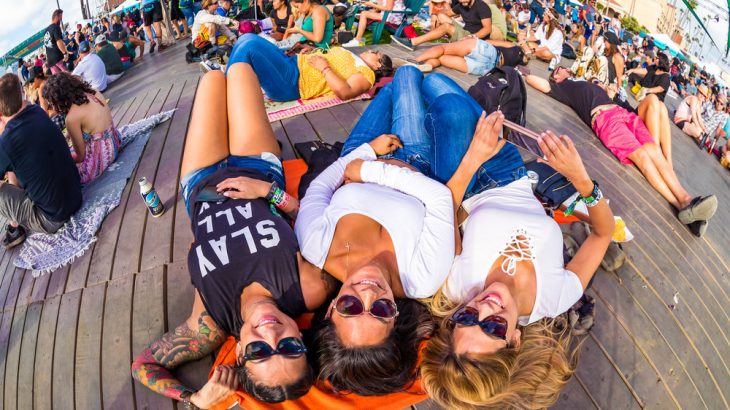 three-women-laying-on-deck-at-festival