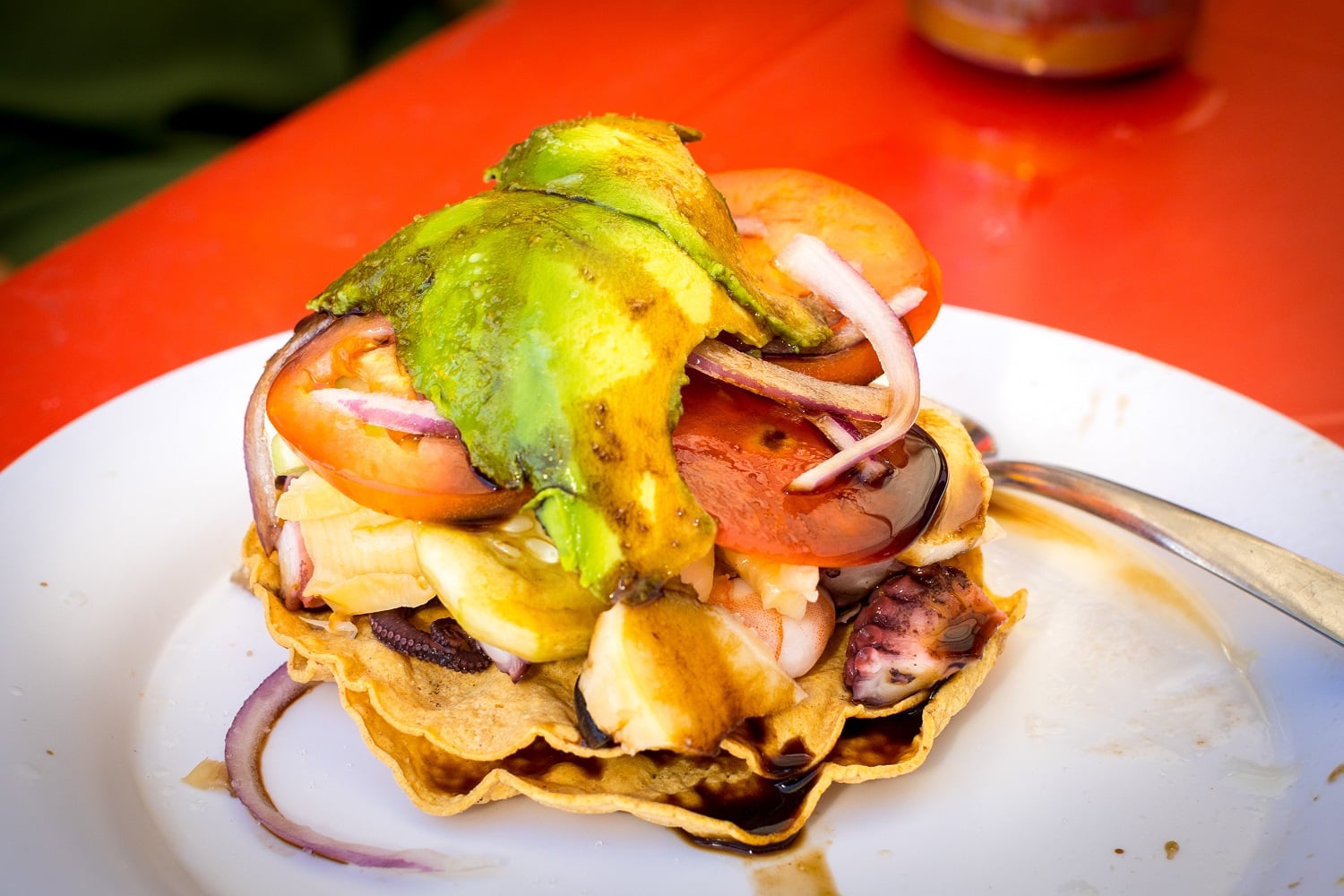 A fresh seafood dish topped with sauce, onions and avocado on a Vallarta Food Tour