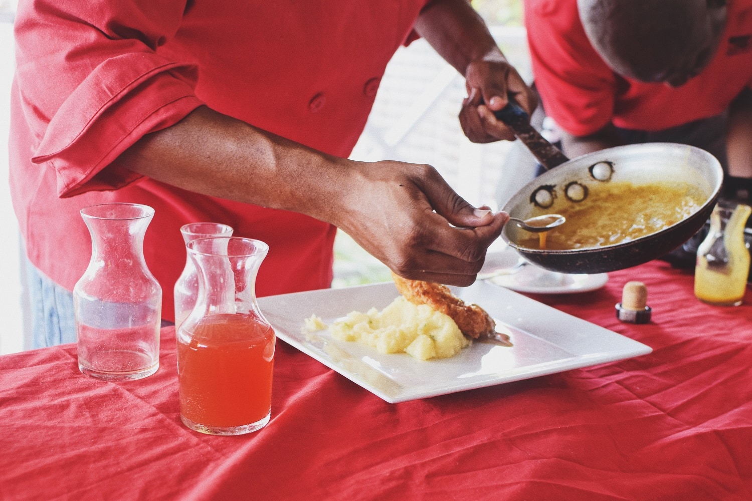 A chef adding sauce to a dish paired with Mount Gay rum on their food pairing tour