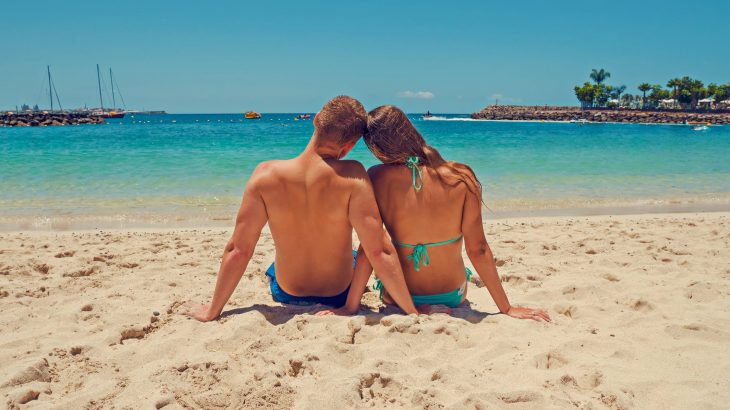 couple-on-beach-looking-over-ocean