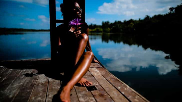 woman-sitting-in-sun-on-dock