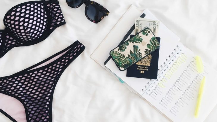 aerial-shot-bikini-passport-phone-sunglasses-on-white-spread