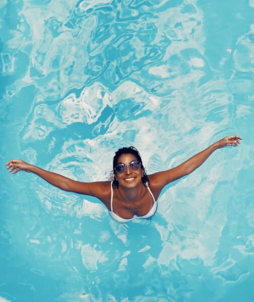 woman-in-pool-holding-hands-out-vacation