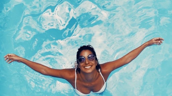 woman-in-pool-holding-hands-out-vacation